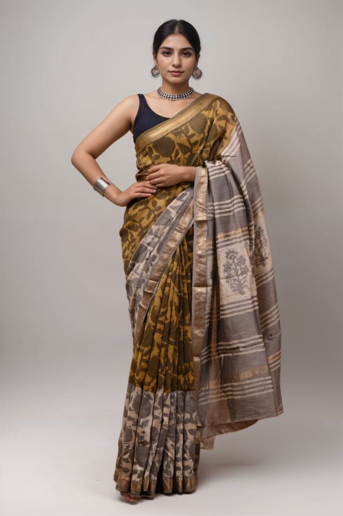 A model draped in an olive green and silver pure Maheshwari silk saree featuring a traditional handwoven pallu and zari detailing, styled with silver jewelry.